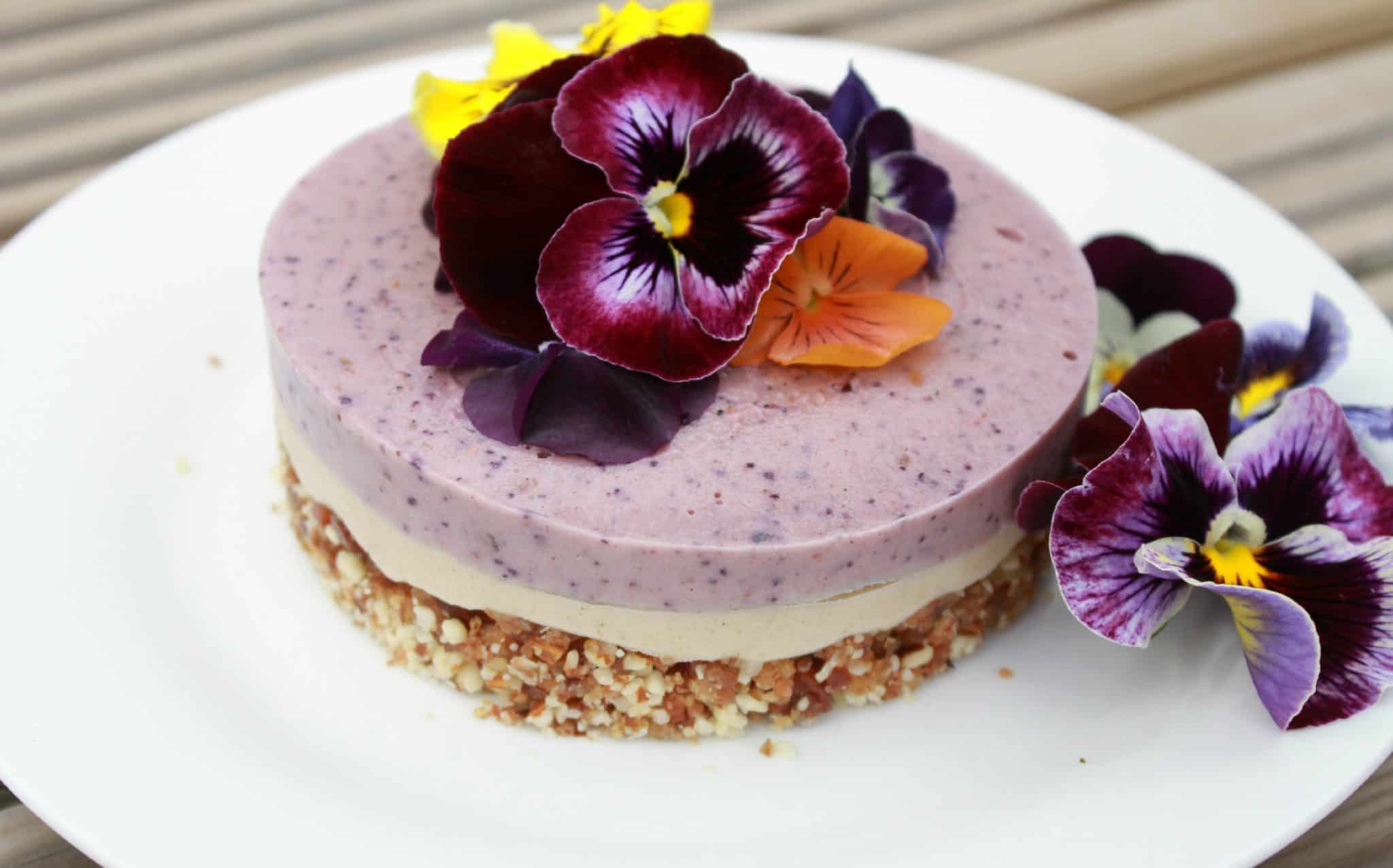 A beautiful raw berry cheesecake decorated with edible flowers from Amy at Mr and Mrs T Plus Three