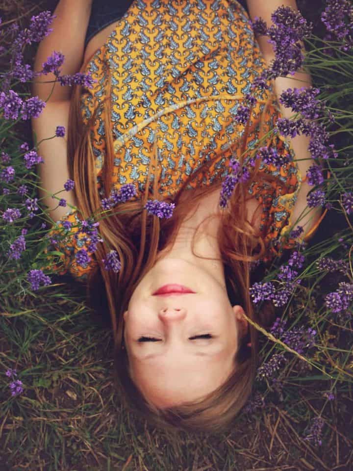 Beautiful girl lying in a field of lavender