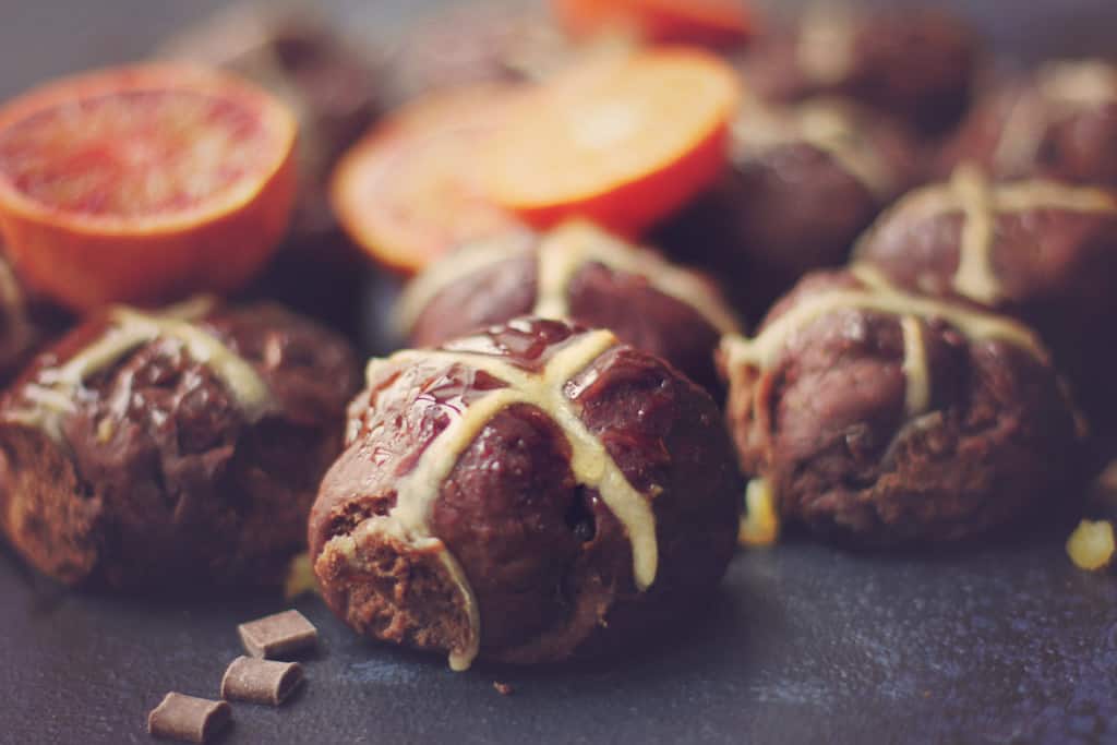 A double chocolate hot cross bun with blood orange and chocolate chips