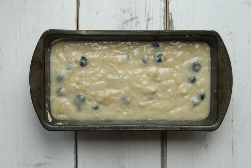 blueberry and banana bread mixture that has been poured into a loaf tin