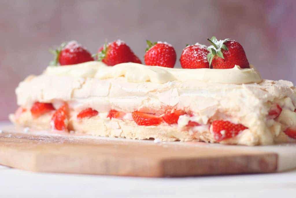 An eton mess roulade topped with whole strawberries