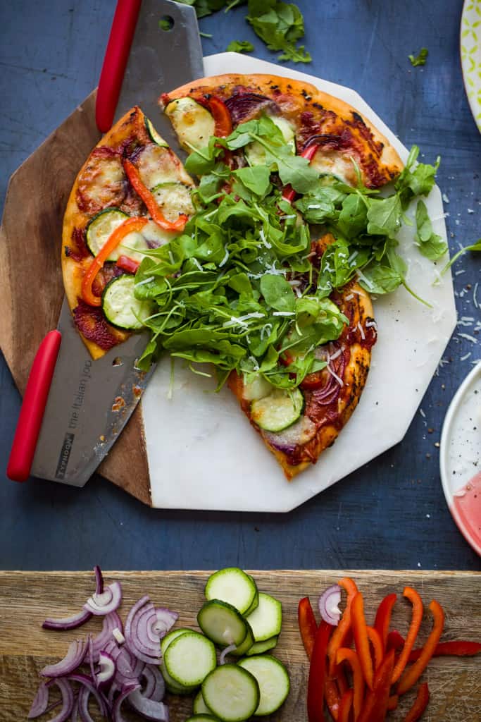 A pizza topped with vegetables and rocket