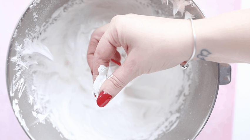checking meringue mixture between fingers