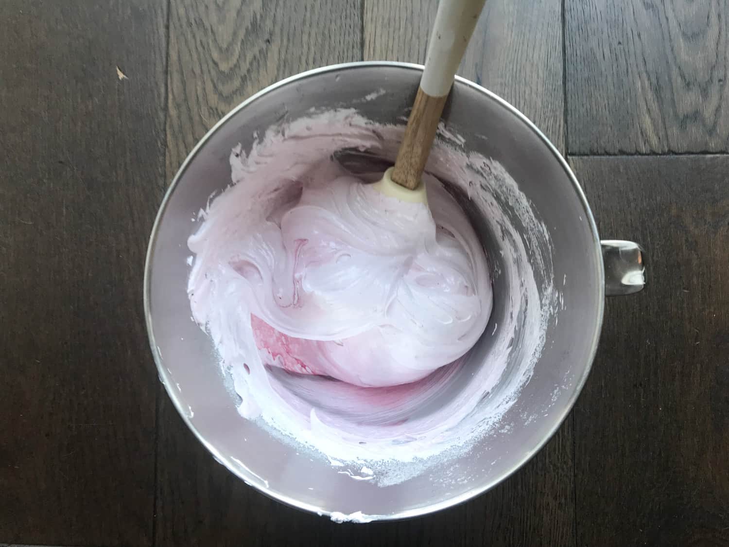 Mixing pink food colouring into meringue