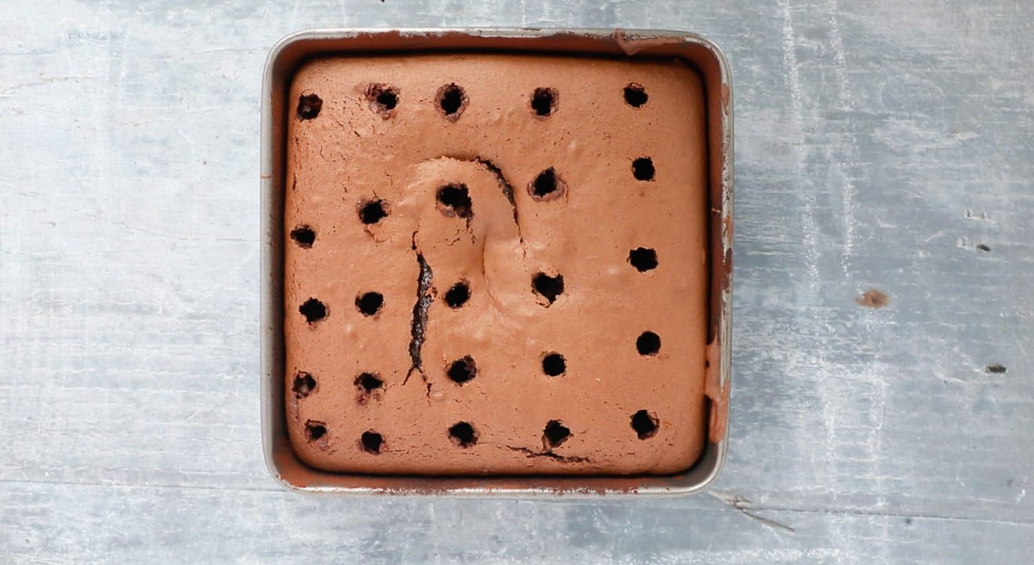 Cake in a pan with holes poked all over it