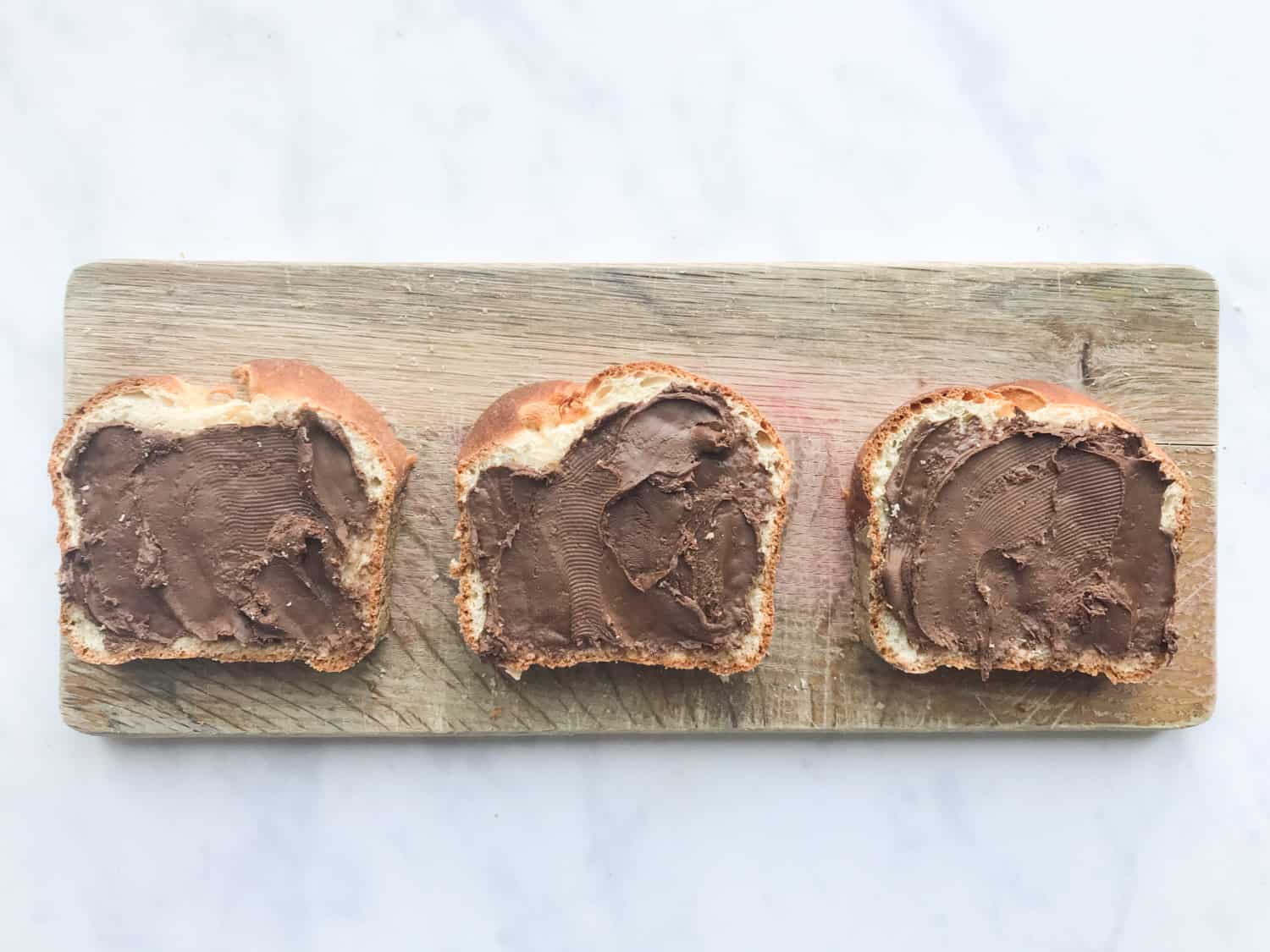 Three slices of brioche bread spread with Nutella