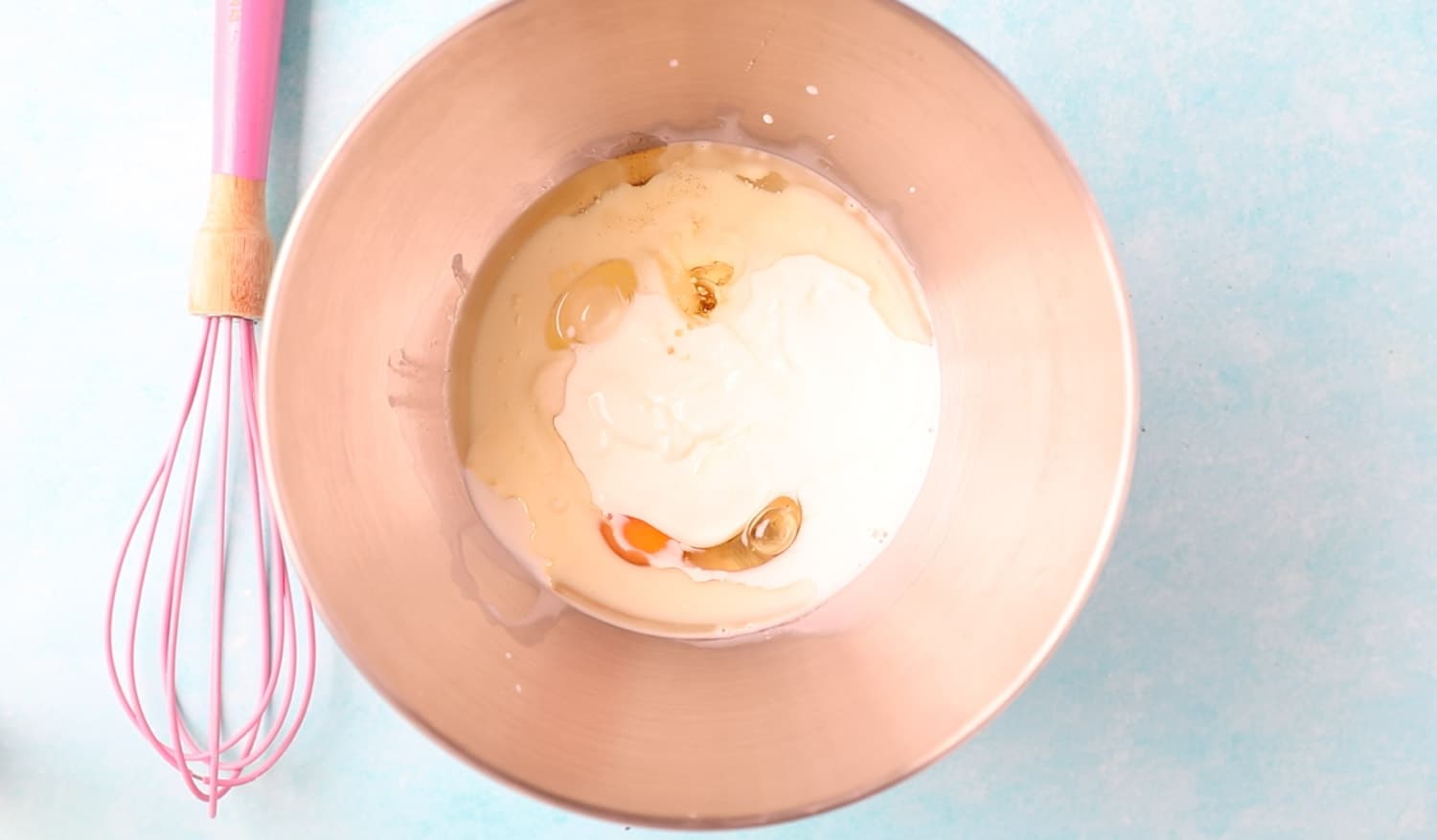 A mixing bowl with egg, milk, yoghurt and vegetable oil
