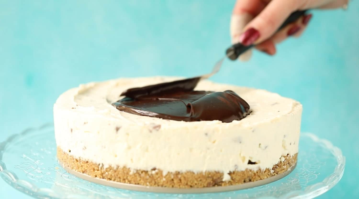 Spreading a cheesecake with chocolate ganache