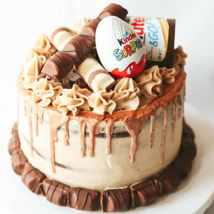 A chocolate layer cake covered with nutella buttercream and decorated with Kinder chocolate
