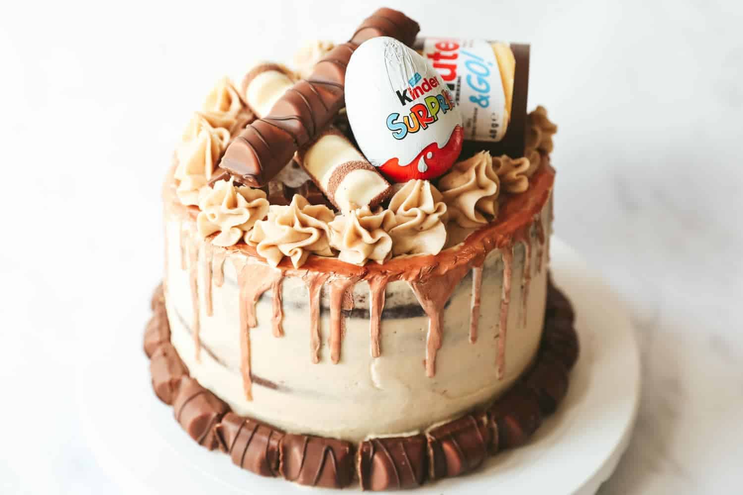 A chocolate layer cake covered with nutella buttercream and decorated with Kinder chocolate