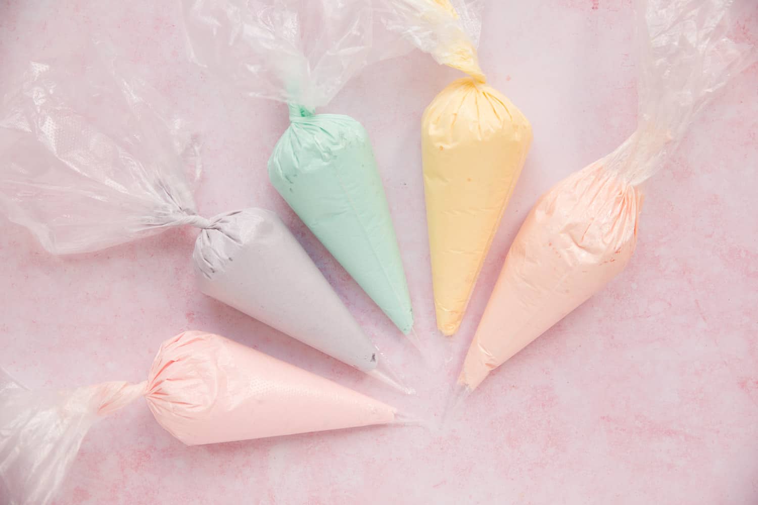 5 disposible piping bags filled with different colour icing