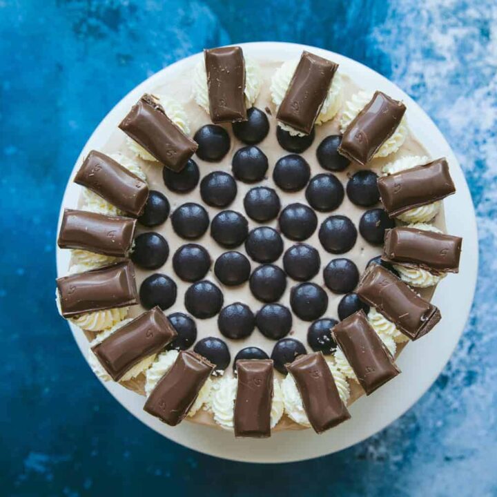 A Galaxy Caramel Cheesecake covered in Minstrels, cream swirls and pieces of Galaxy Caramel
