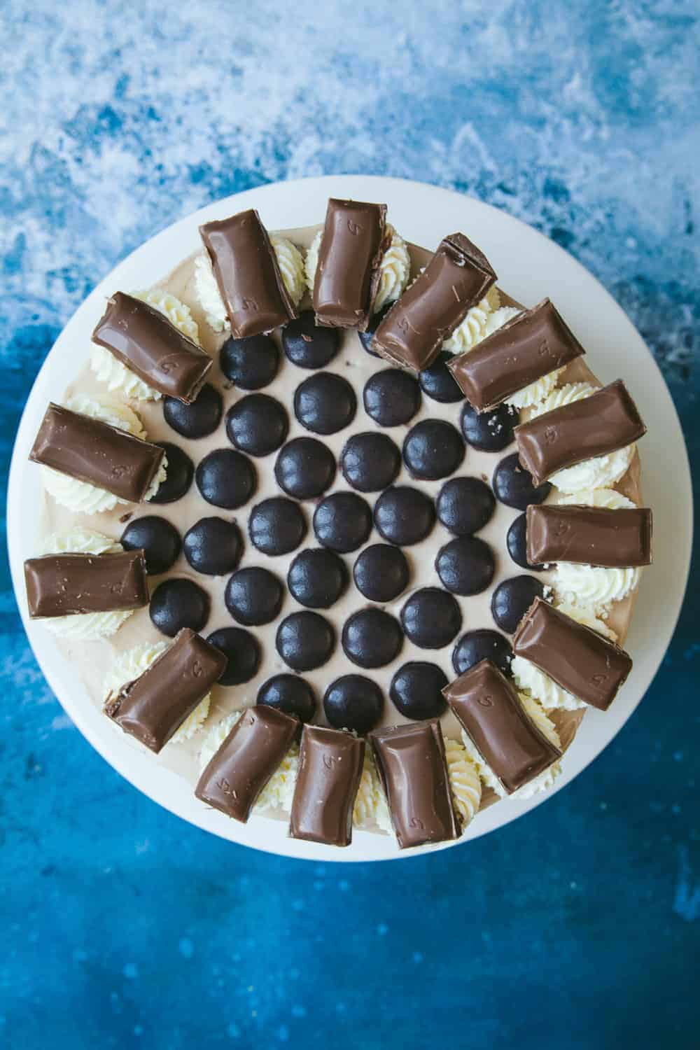 A Galaxy Caramel Cheesecake covered in Minstrels, cream swirls and pieces of Galaxy Caramel