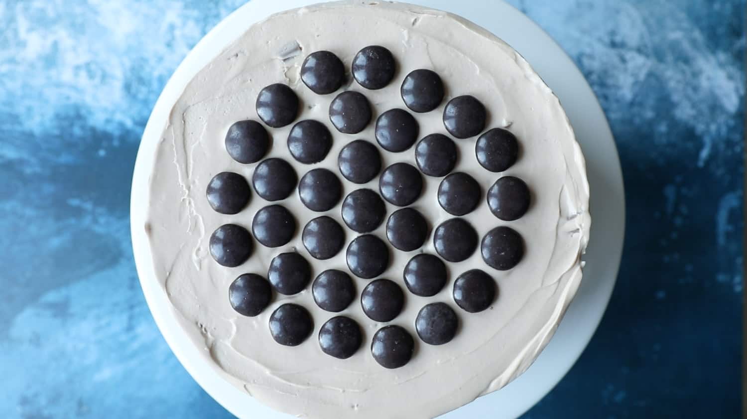 An overhead shot of a Galaxy Caramel Cheesecake with a spiral pattern of Minstrels on top. 