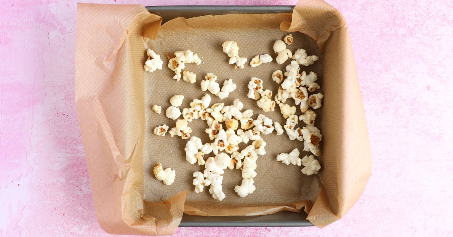 A layer of popcorn in a square baking tin.