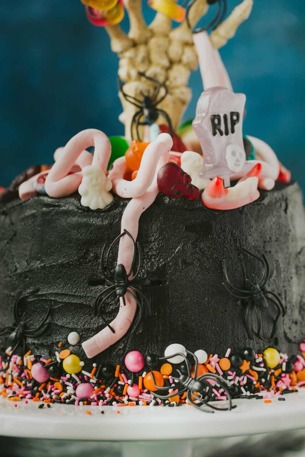 A black halloween cake covered with halloween sweets. 