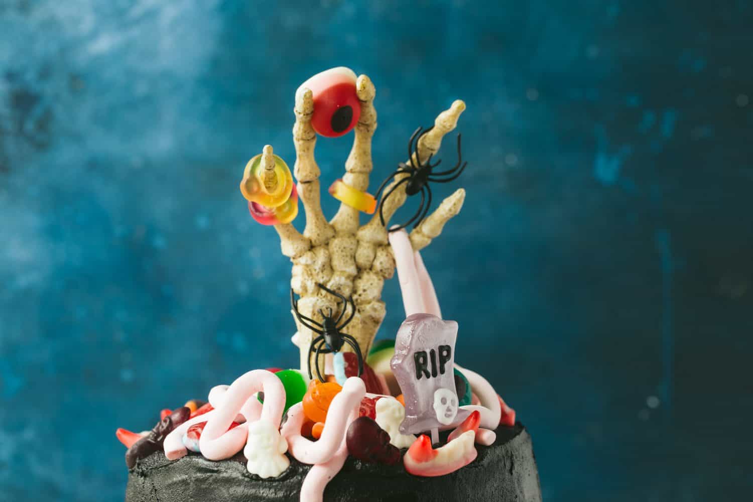 A skeleton hand with Halloween sweets.