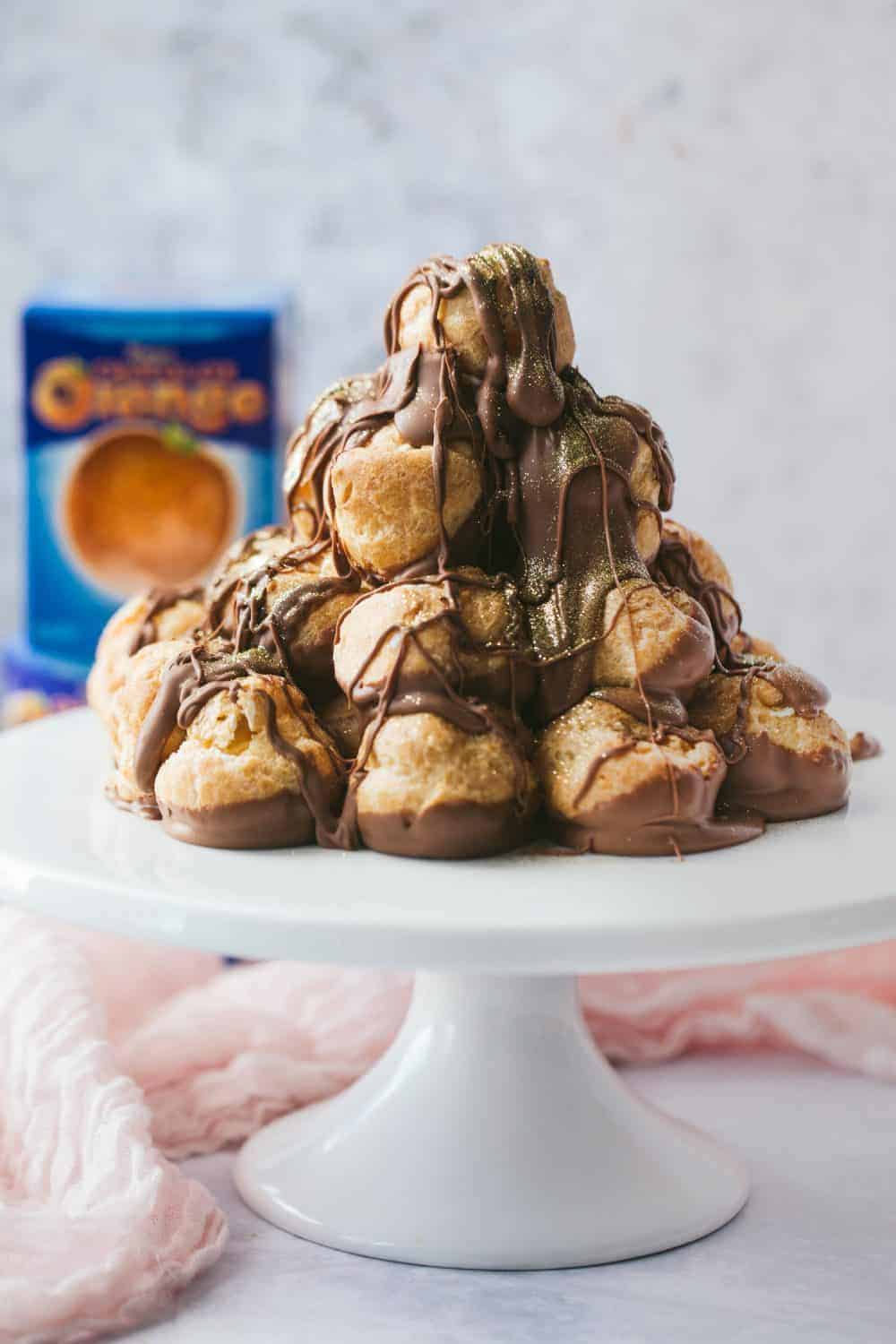 A profiterole tower covered in chocolate sauce.