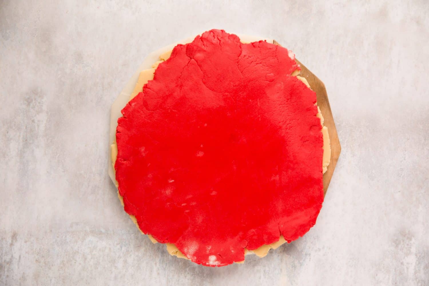 A sheet of red coloured vanilla biscuit dough. 