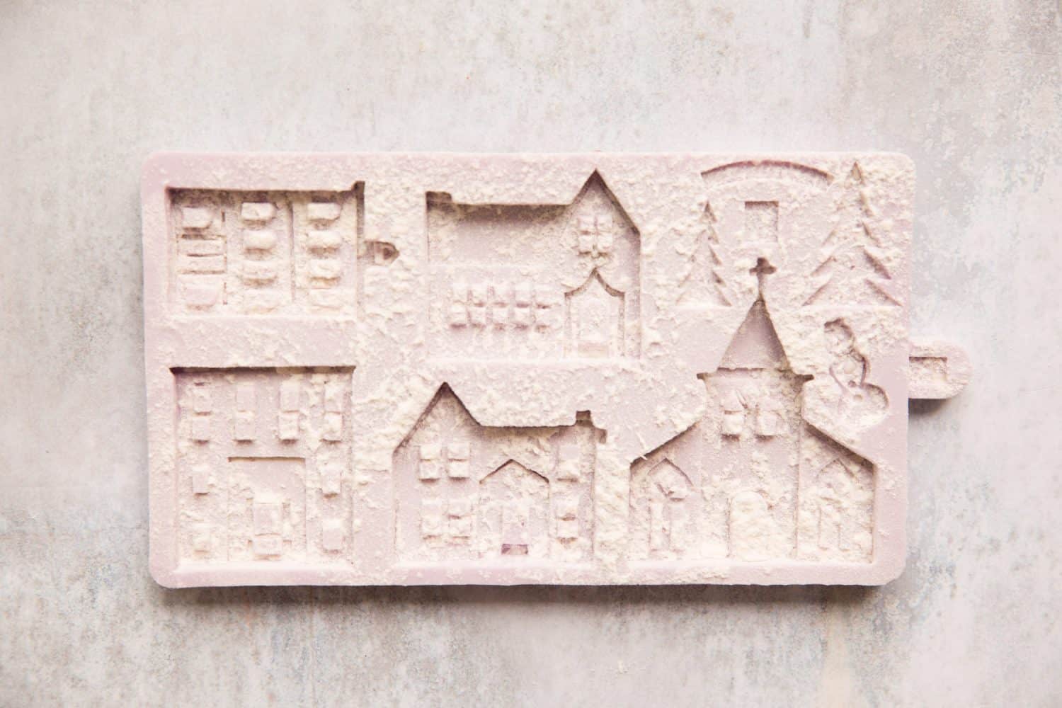A gingerbread house mould that has been dusted with flour.