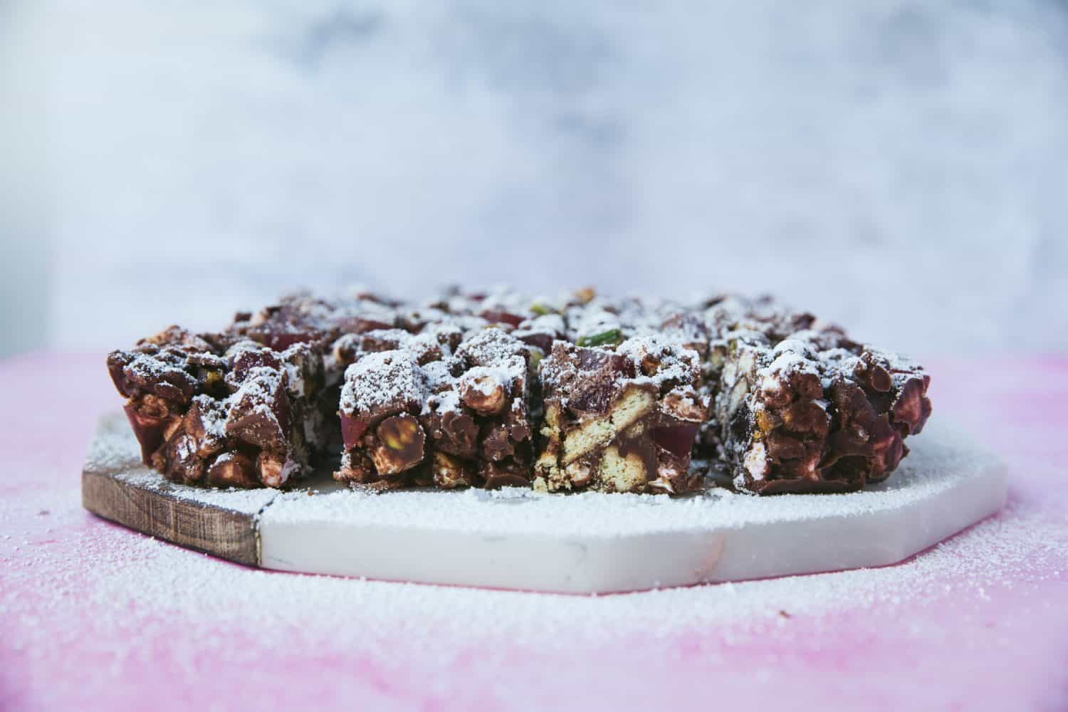 Turkish Delight and Pistachio Rocky Road bars that have been cut into squares and dusted with icing sugar. 