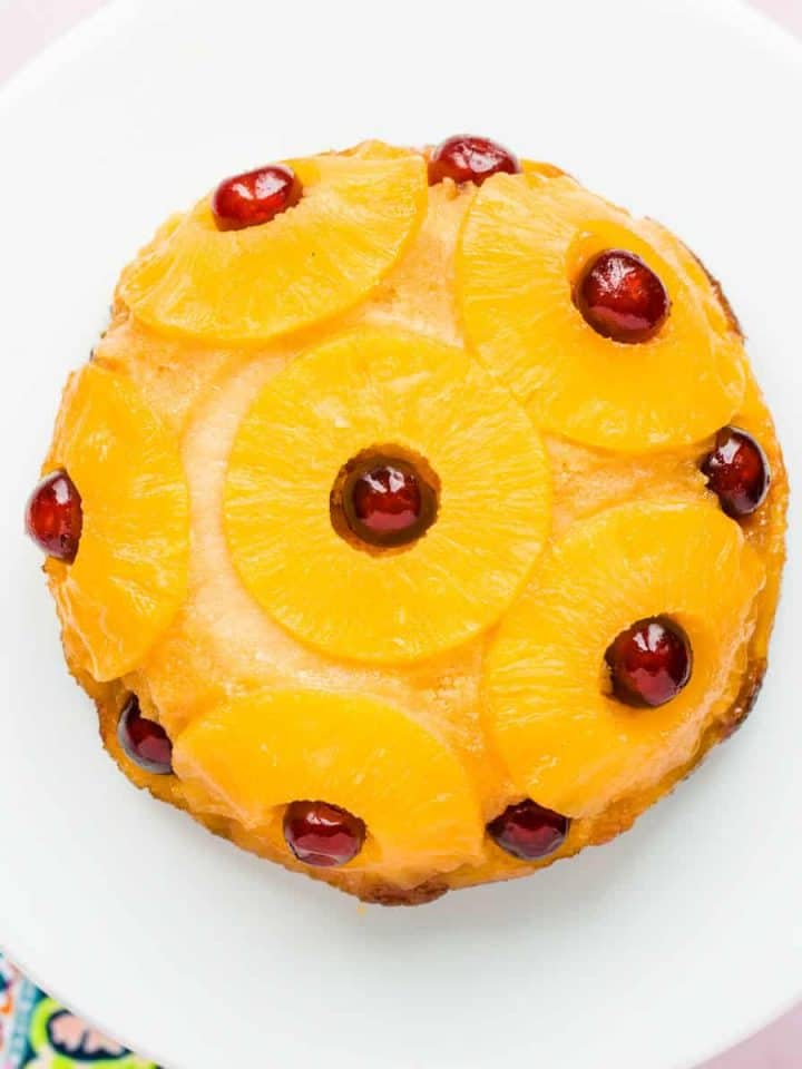 Overhead view of a pineapple upside down cake on a white plate