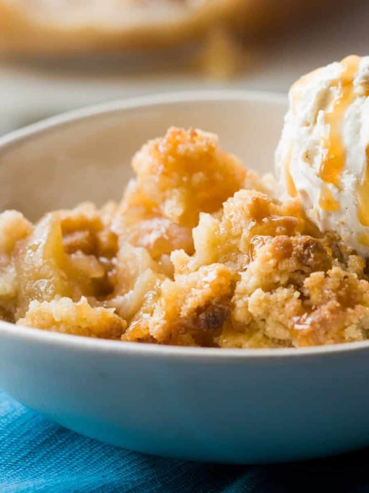 Apple crumble with ice cream on top in a white bowl