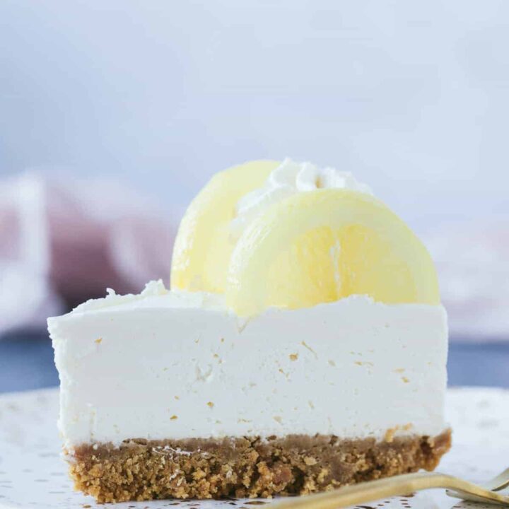 A slice of lemon cheesecake with pieces of lemon on top.