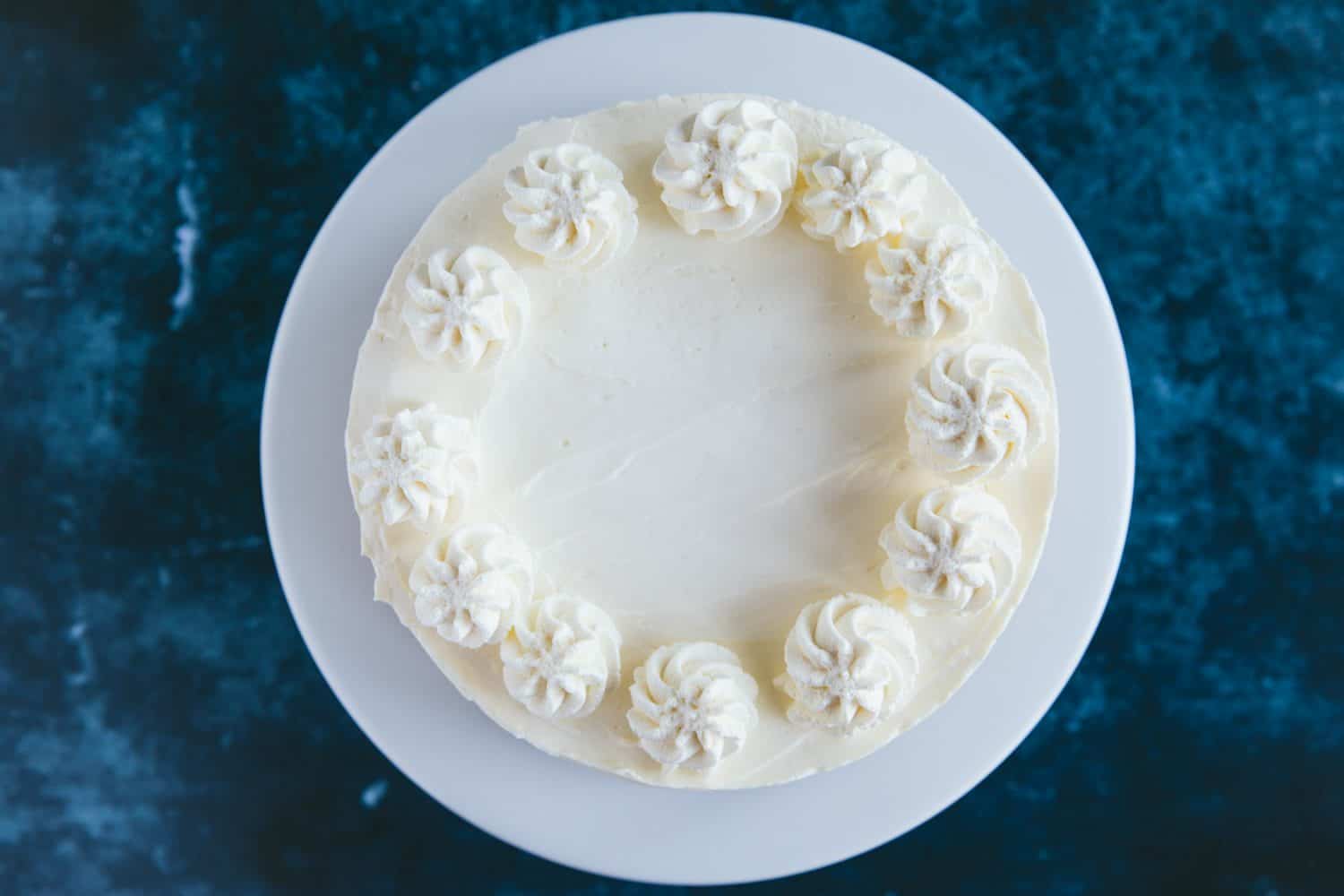 A cheesecake with swirls of piped cream on top. 