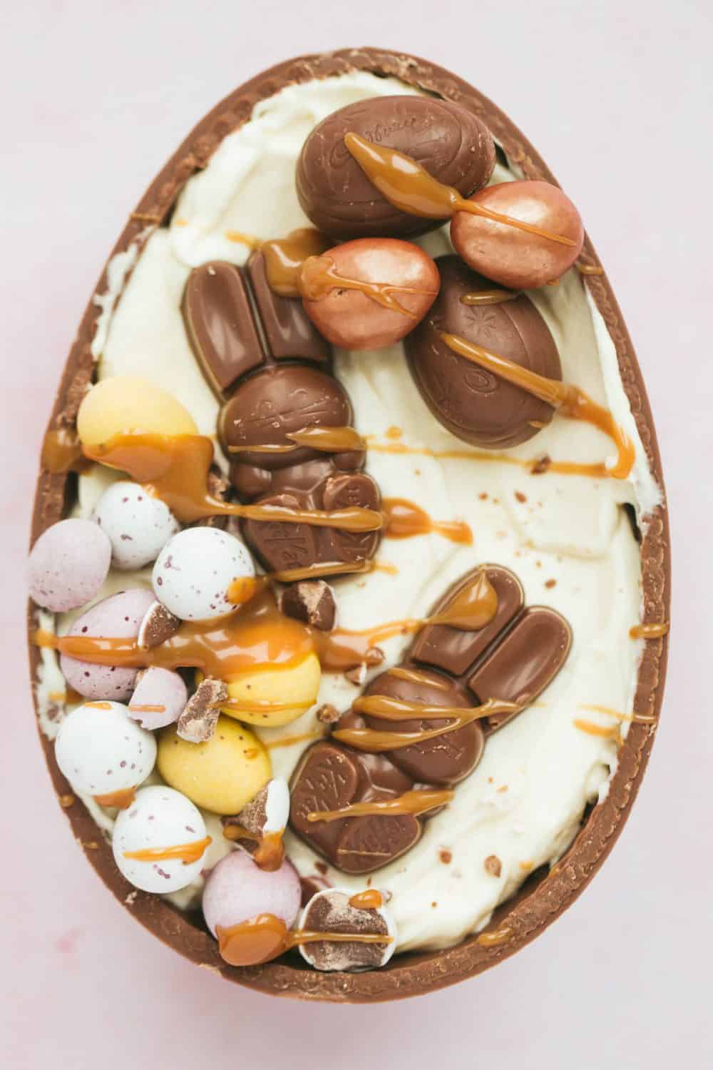 An Easter egg shell filled with cheesecake filling, Easter bunny chocolate and mini eggs. 