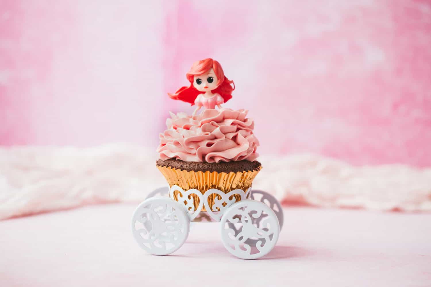 An Ariel cupcake on a white chariot cupcake holder. 