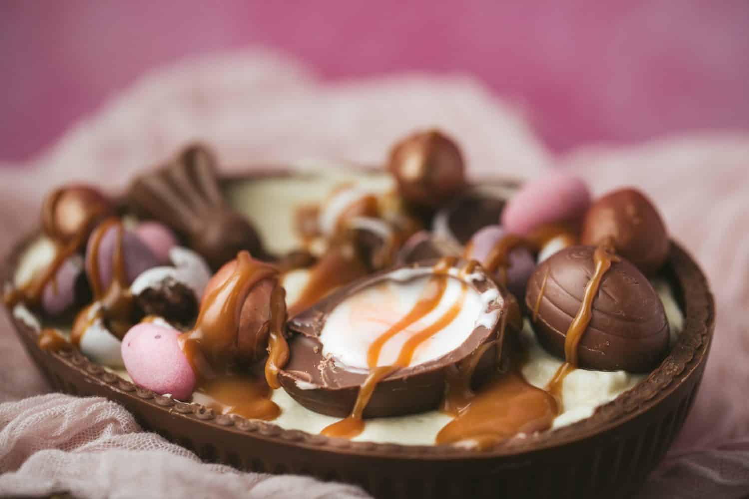 Half a large chocolate Easter egg filled with cheesecake and topped with Easter chocolate. 
