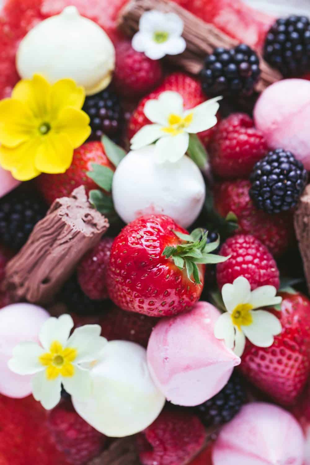 Strawberries, blackberries, raspberries, mini meringues, chocolate flakes and flowers. 