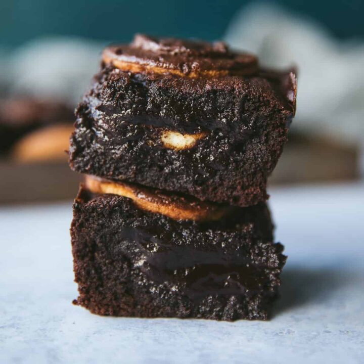 Fudgy Jaffa Cake Brownies stacked on top of each other.