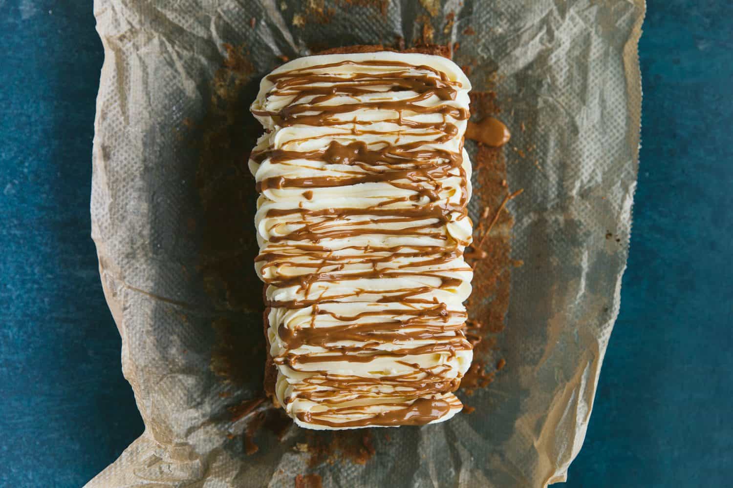 A rectangular shaped cake that has been covered in buttercream and drizzled with Biscoff Spread. 