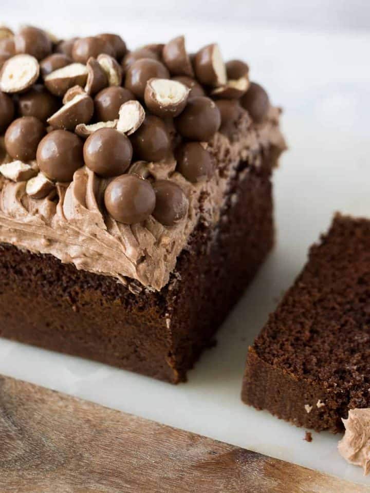 A Malteser loaf cake that has a slice cut out.