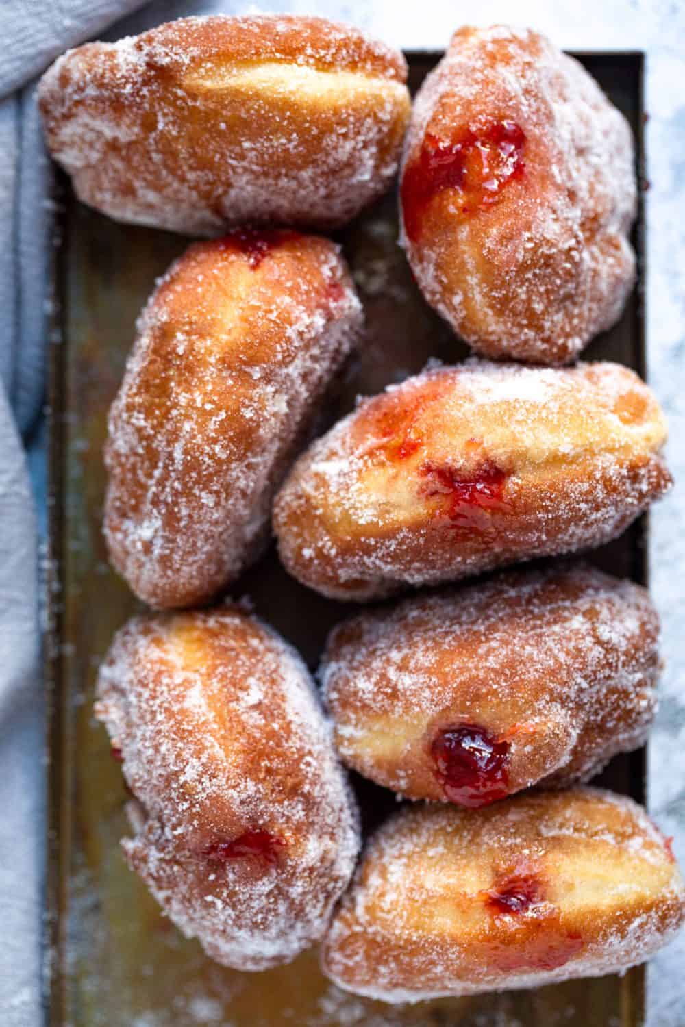 A tray of freshly made jam doughnuts. 
