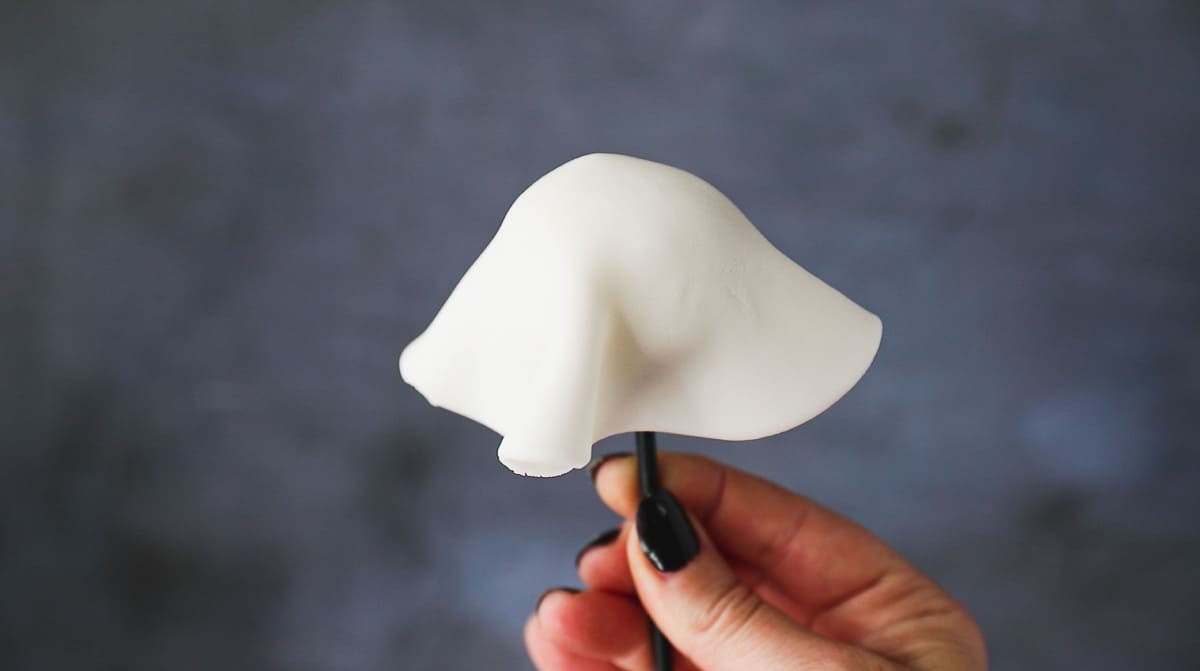 Covering a round cake pop with a circle of white fondant to make it look like a ghost. 