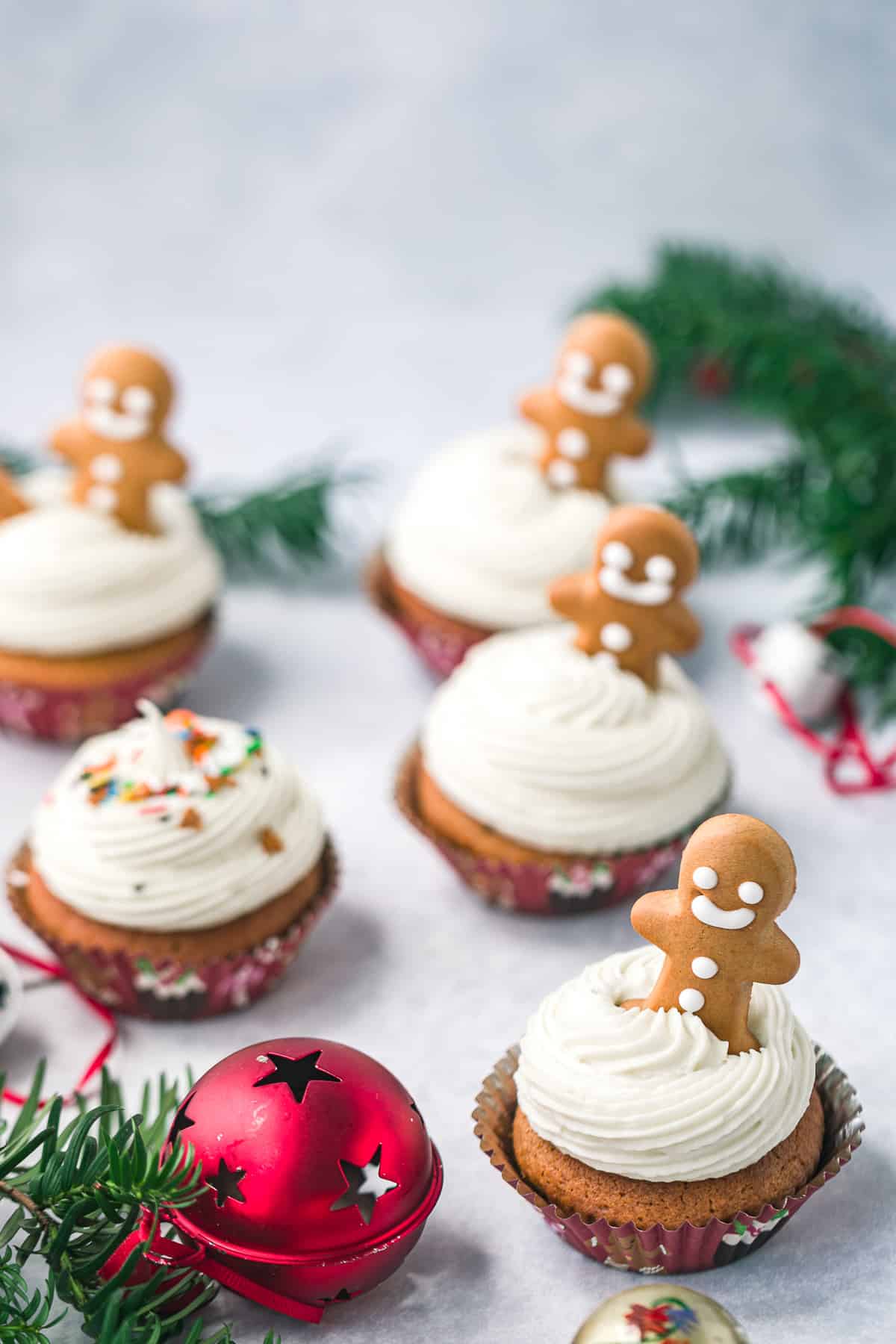5 gingerbread cupcakes topped with cream cheese frosting and a mini gingerbread man. 