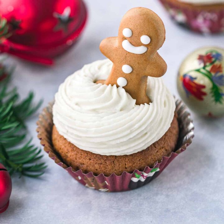A gingerbread cupcake with a gingerbread man added into the cream cheese frosting.