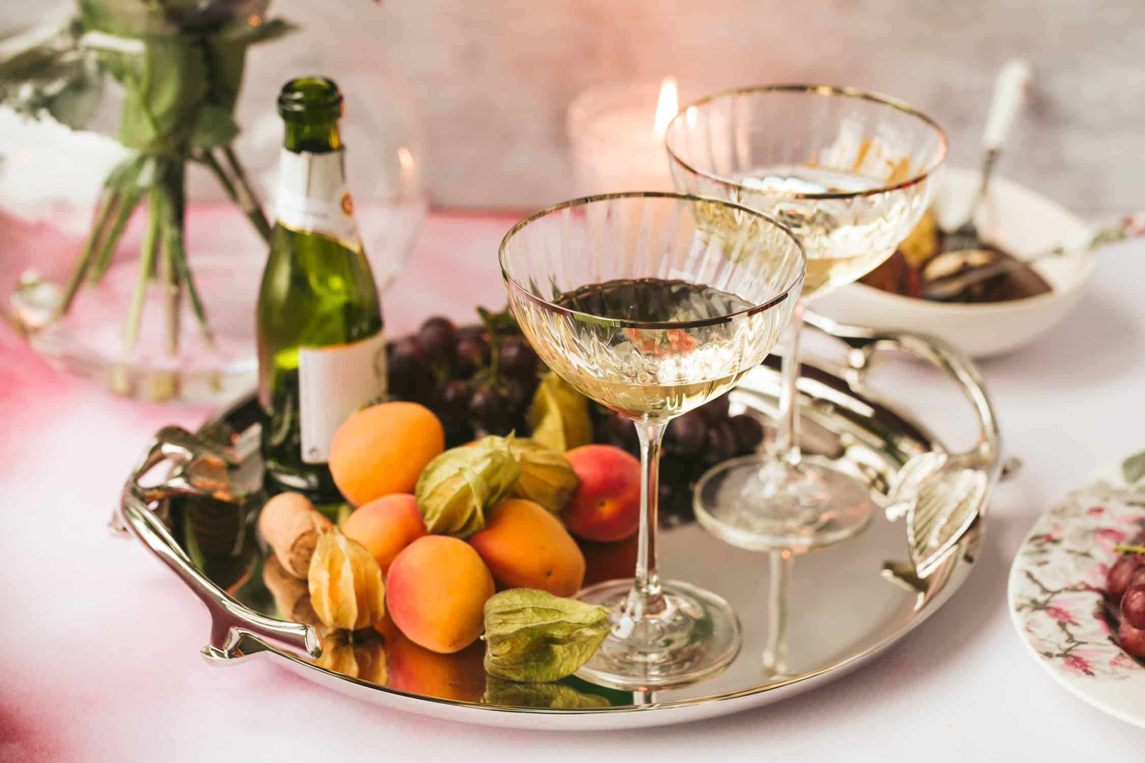 A silver tray with champagne saucers and fresh fruit. 