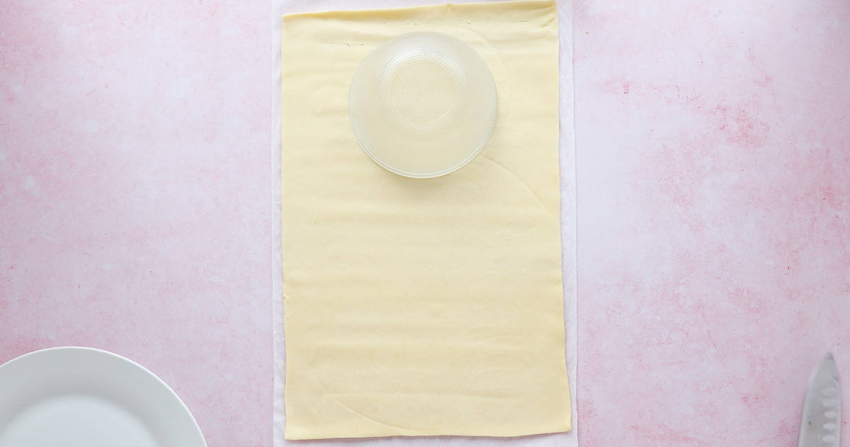 A sheet of pastry with a bowl being used as a template.