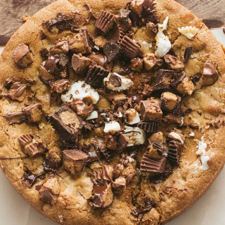 A peanut butter cookie pie covered with Reese's mini cups.