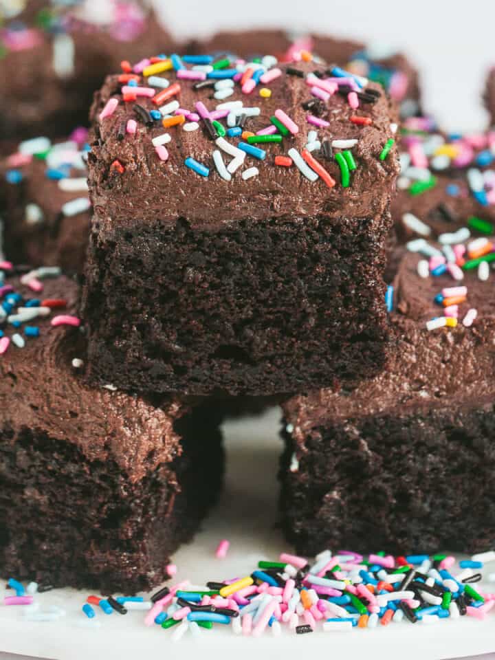 Three pieces of chocolate sprinkle cake stacked on top of each other.