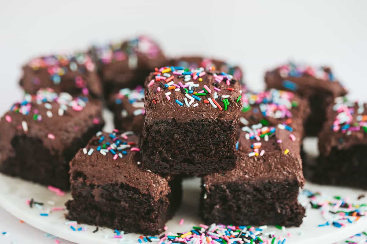 Slices of chocolate sheet cake covered with colourful sprinkles. 