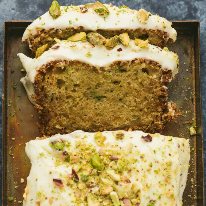 A courgette cake with two slices cut out of it.