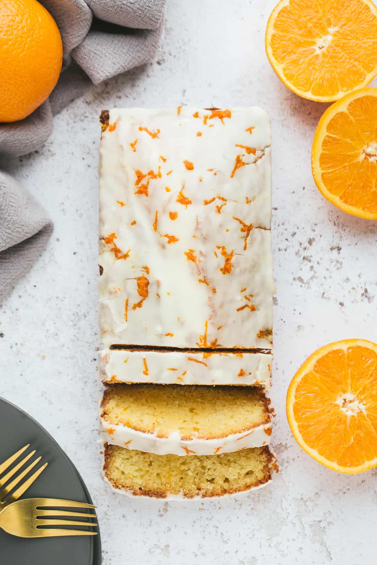 A orange drizzle cake with a white coloured orange flavoured icing on top. 