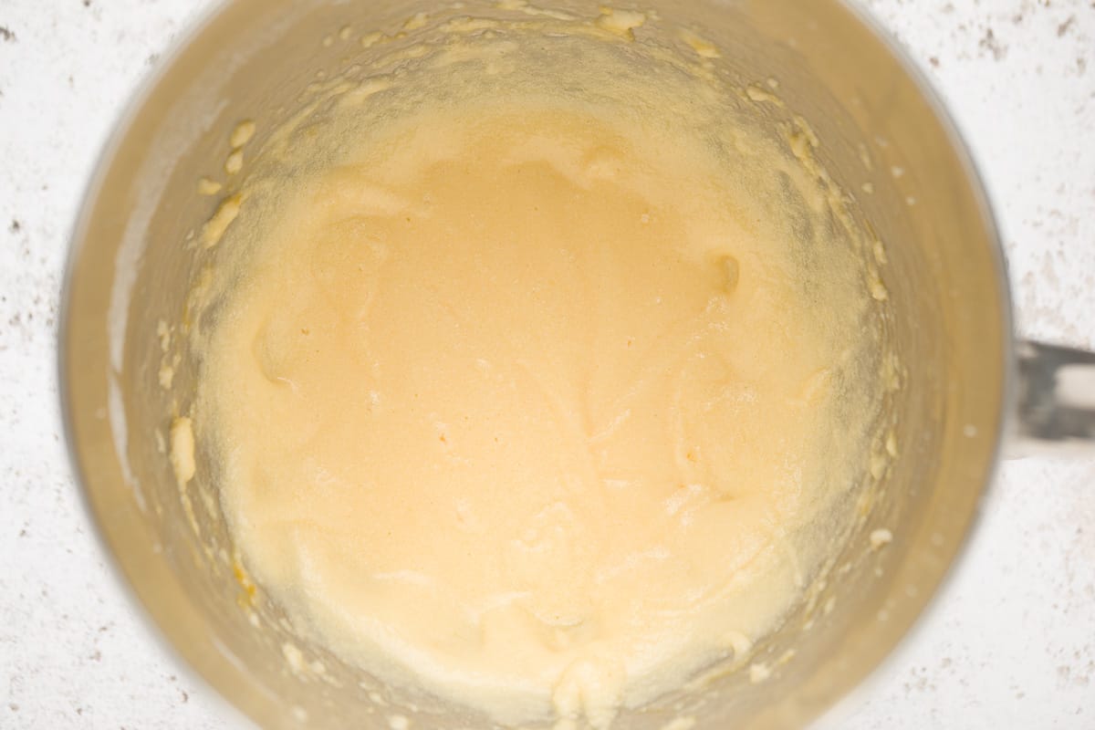 A mixing bowl with creamed butter and sugar and eggs that have been beaten in. 
