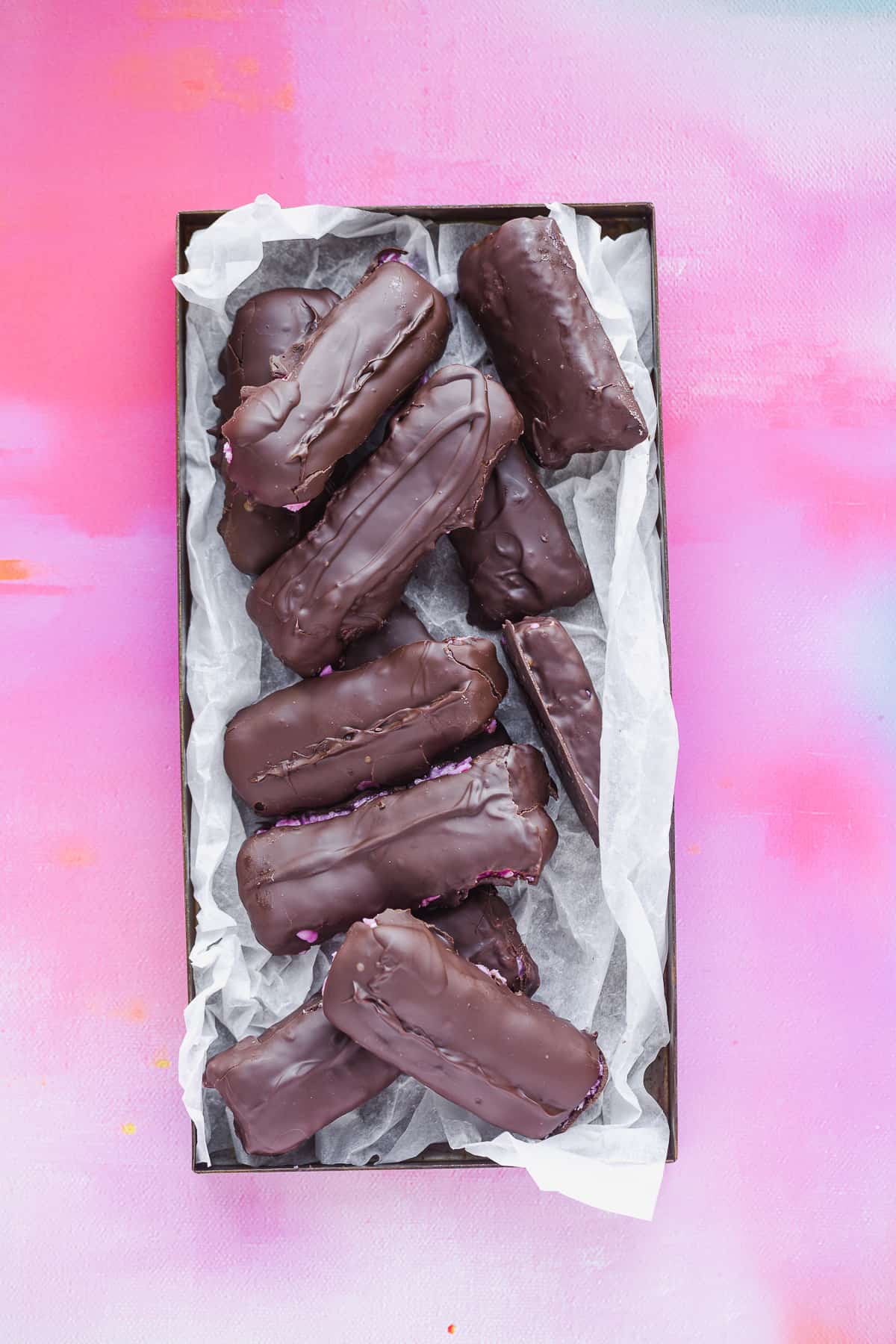 A tray of homemade bars that have been dipped in a combination of milk and dark chocolate. 