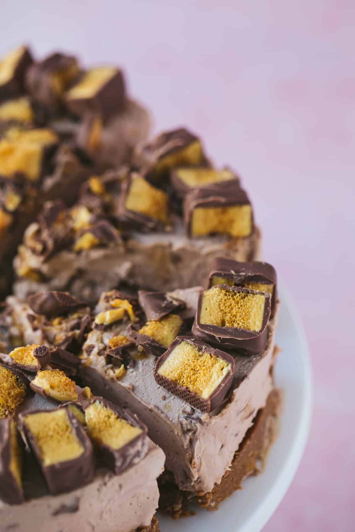 Slices of a no bake chocolate cheesecake that has been topped with pieces of Crunchie bar. 